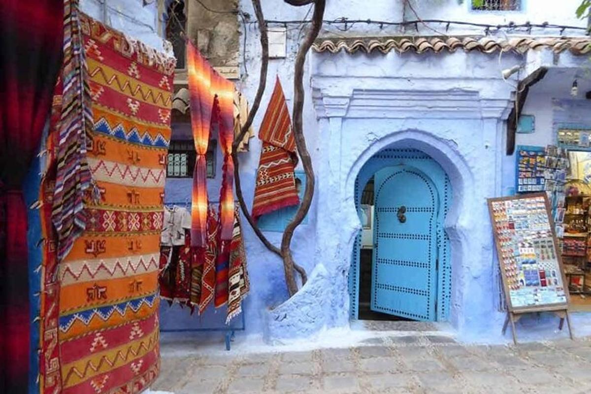 Un edificio azul con una puerta azul y un cartel.