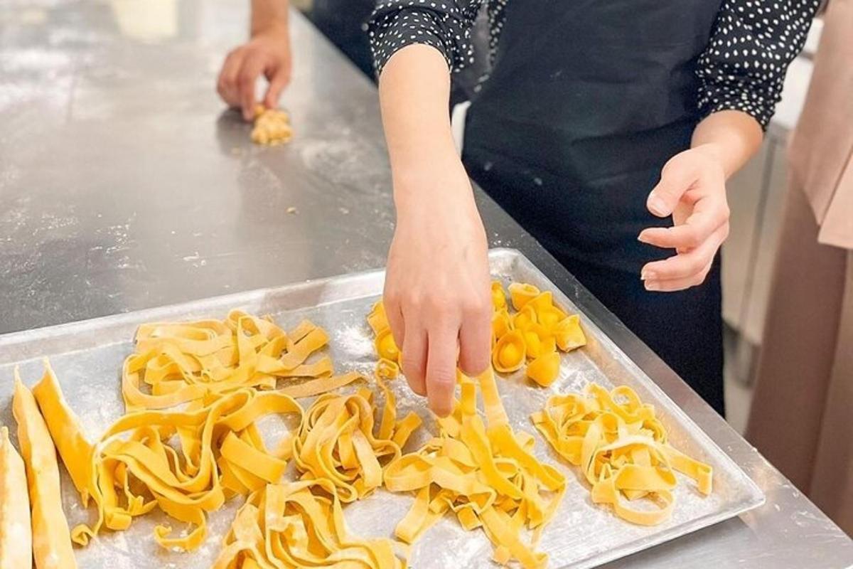 henkilö valmistaa pastaa tiskillä