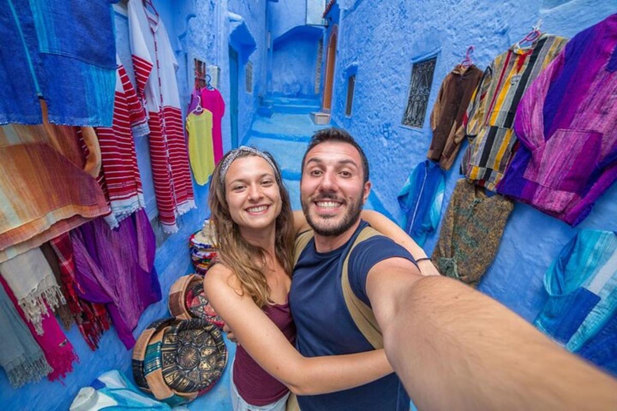 moški in ženska pozirata pred modro stavbo