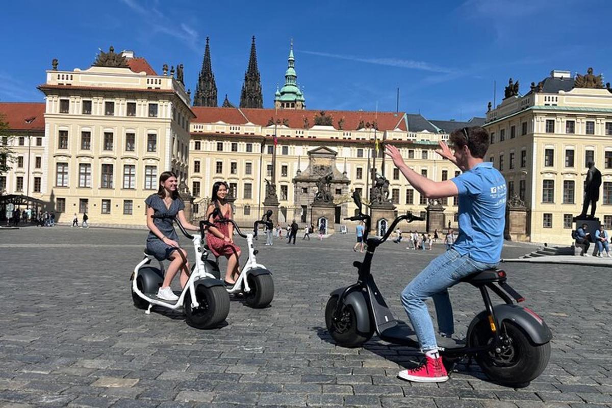három ember robogózik egy épület előtt