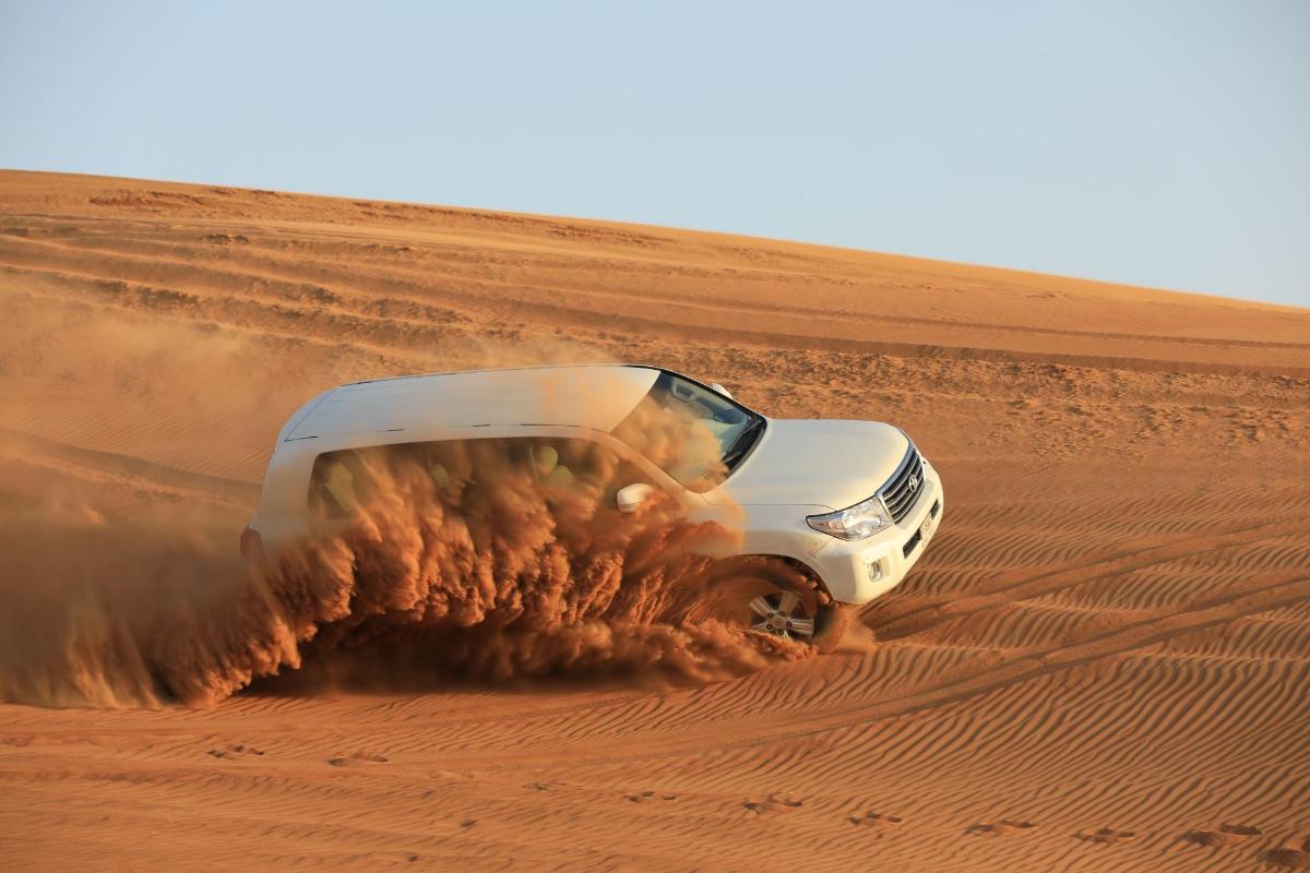 um caminhão branco dirigindo no deserto