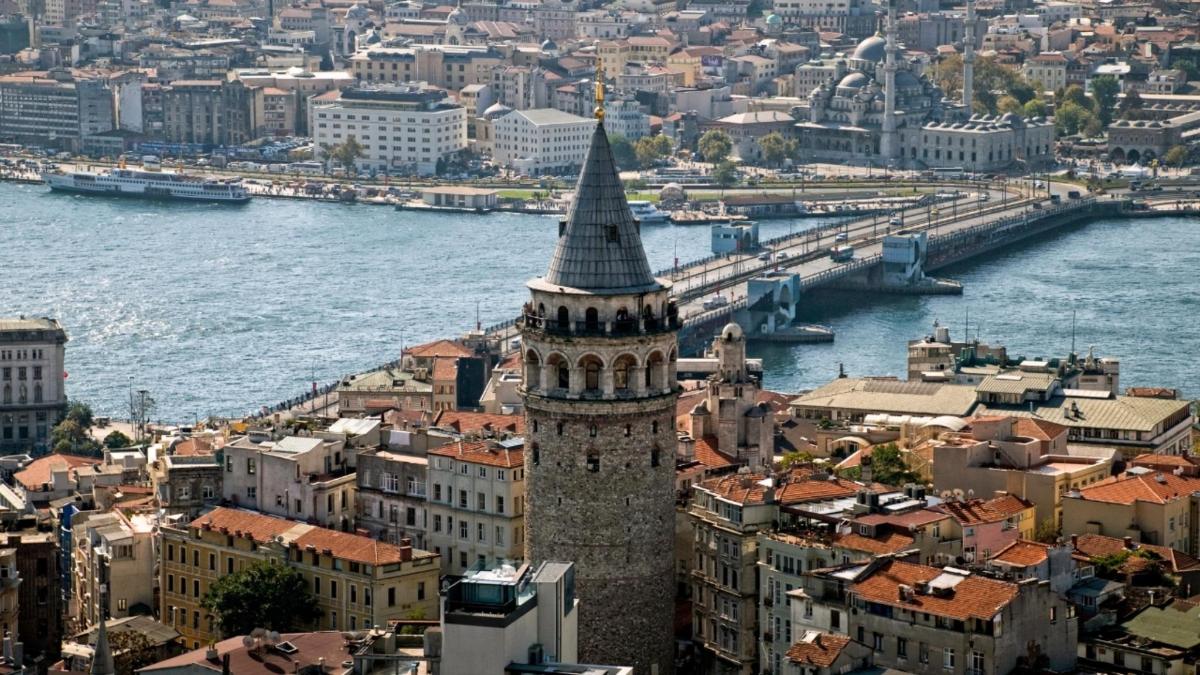 a tall building with a steeple next to a river