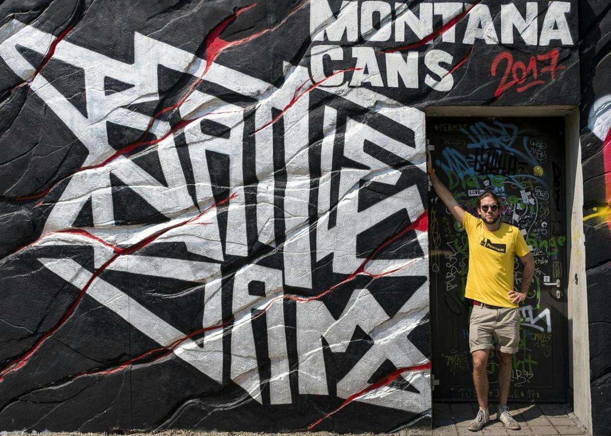 muž stojící před zdí s graffiti
