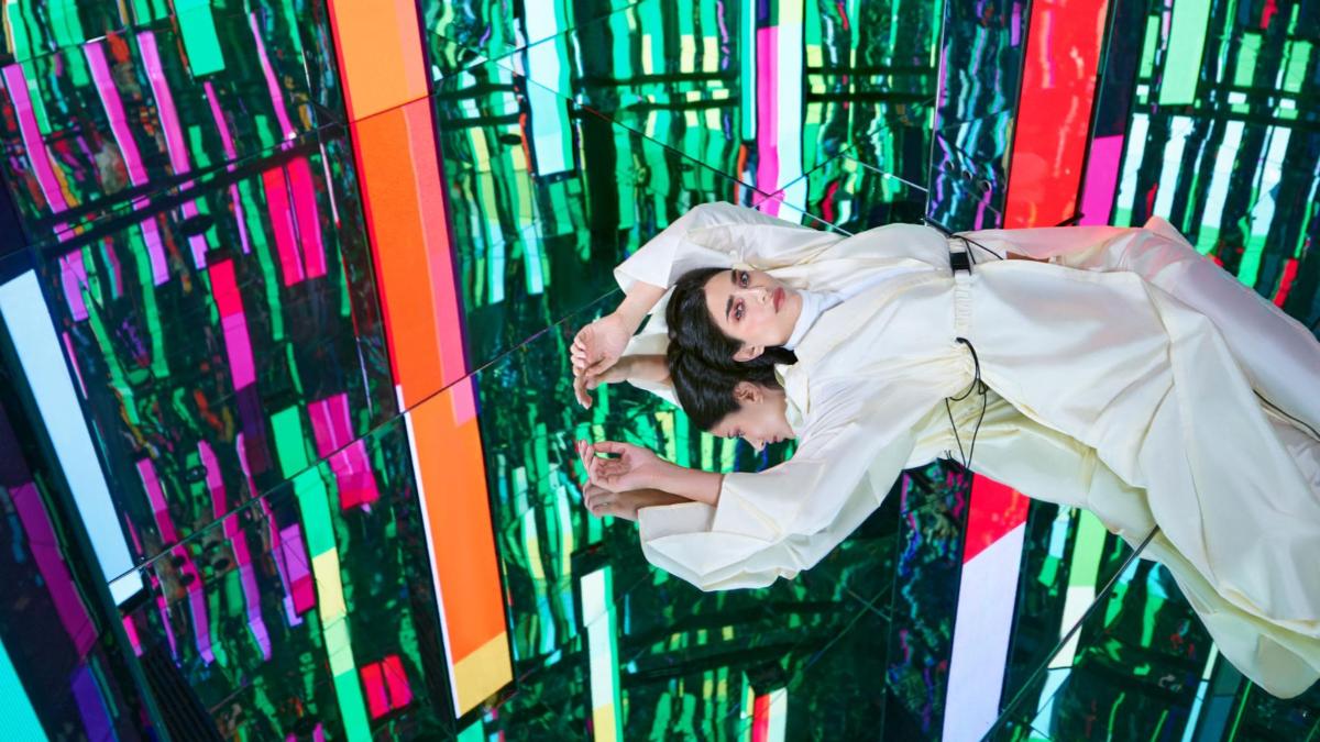 a man and woman are posing in front of a painting