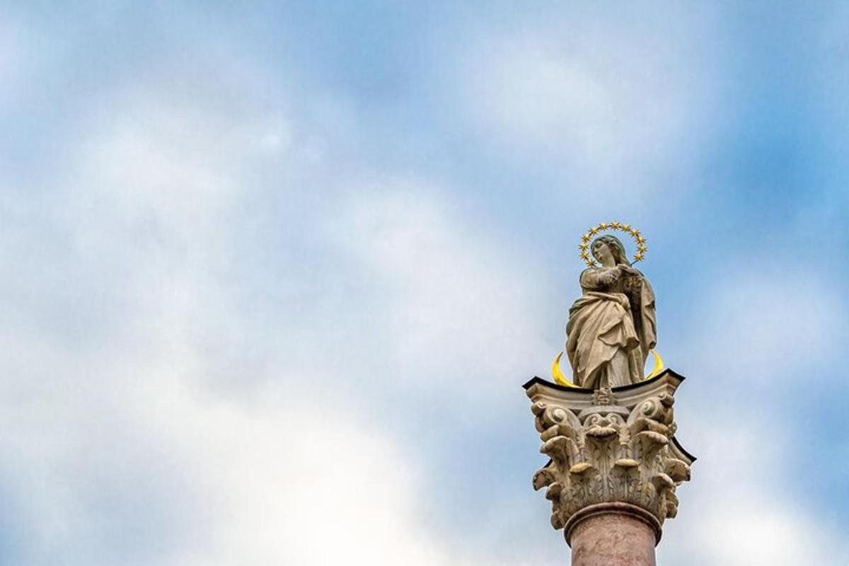 una estàtua asseguda a sobre d'un pal