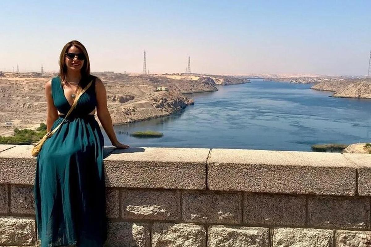 eine Frau in einem blauen Kleid steht neben einem Fluss