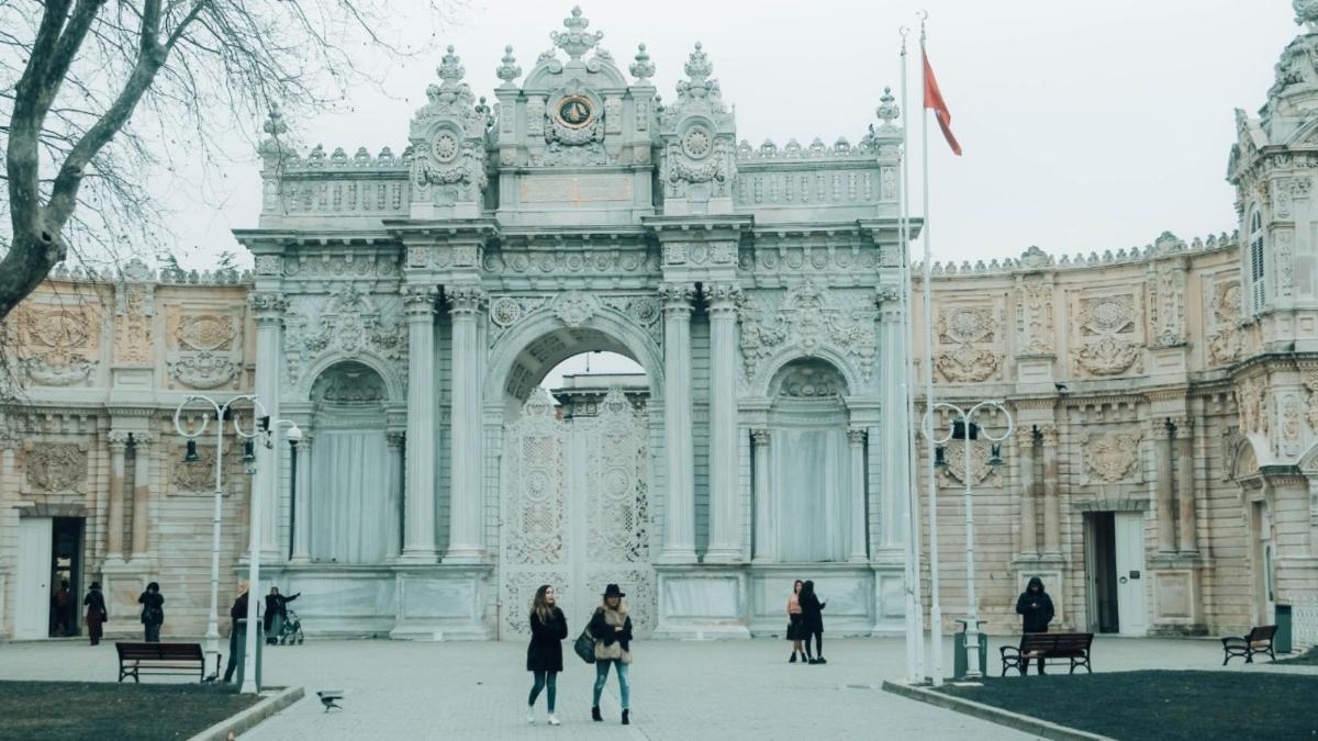 a building with an arch with people walking in front of it