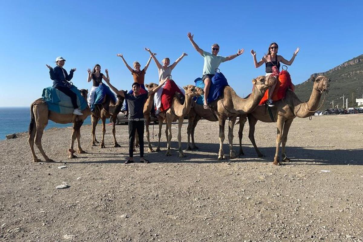 un gruppo di persone a cavallo di cammelli sulla spiaggia