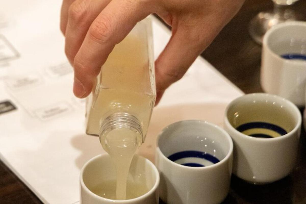 a person is pouring liquid into two cups