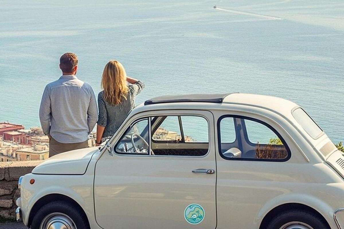 Un hombre y una mujer de pie junto a un coche.