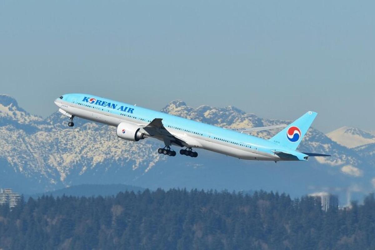 un aereo blu e bianco sta volando nel cielo