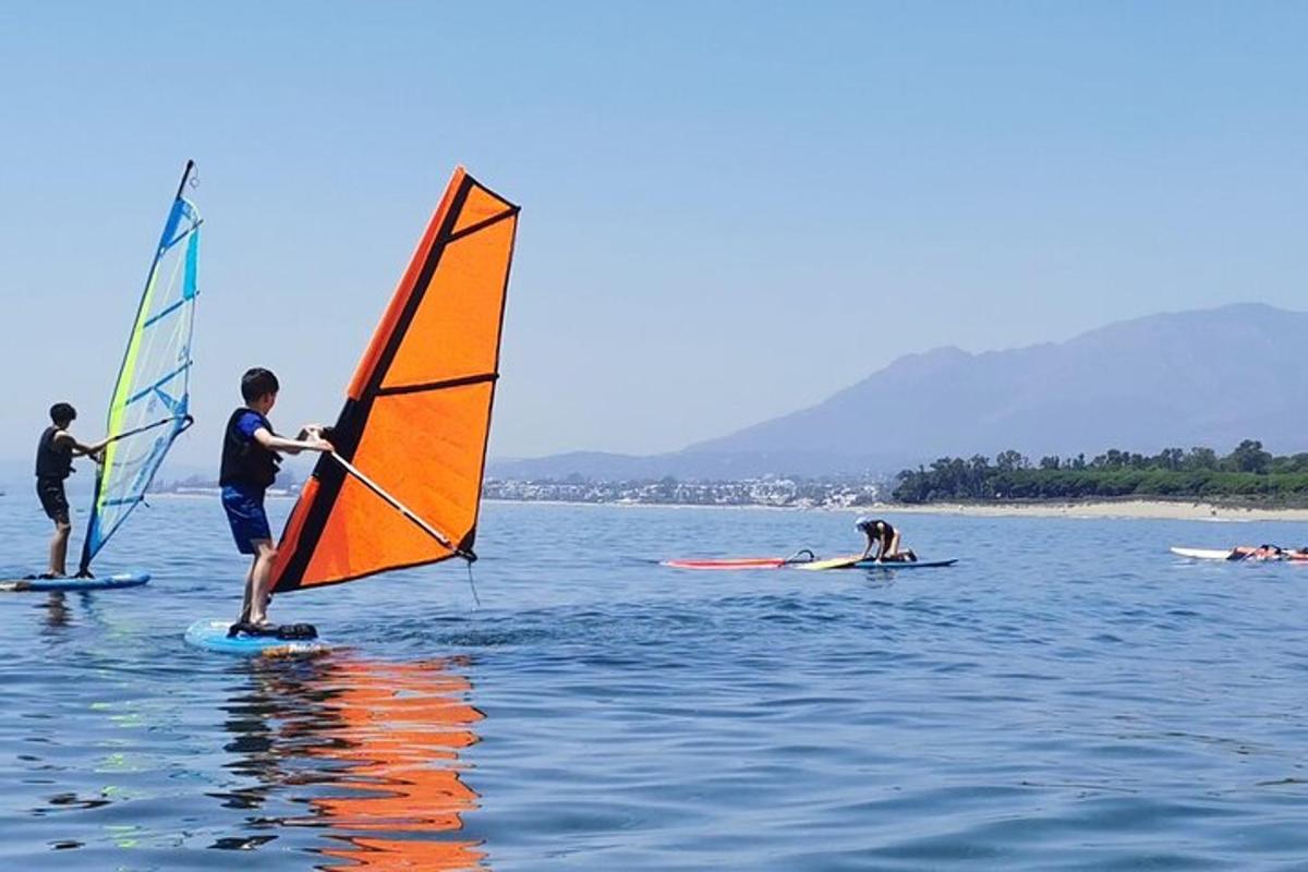 a group of people windsurfing on the water