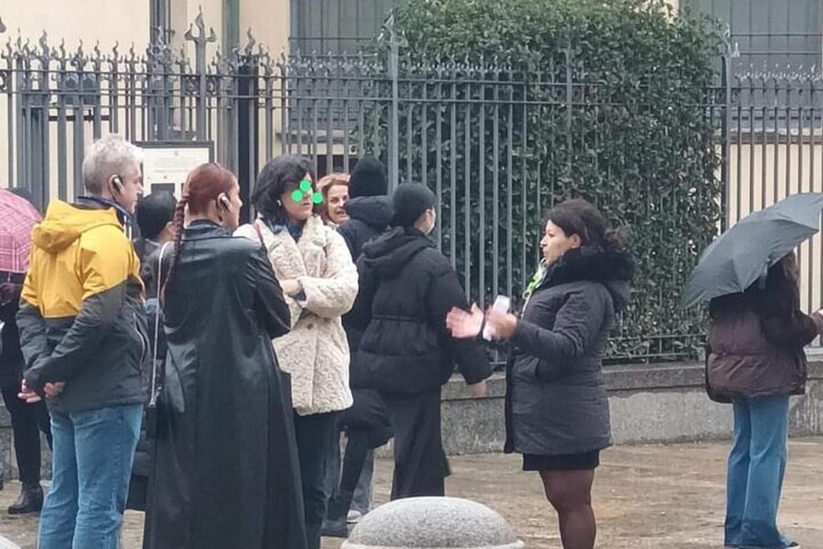 Un grupo de personas de pie frente a una valla