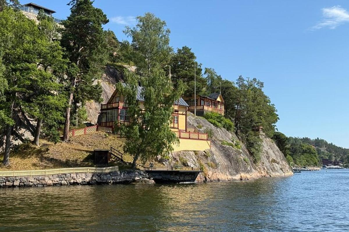 talo kukkulan rinteessä veden vieressä