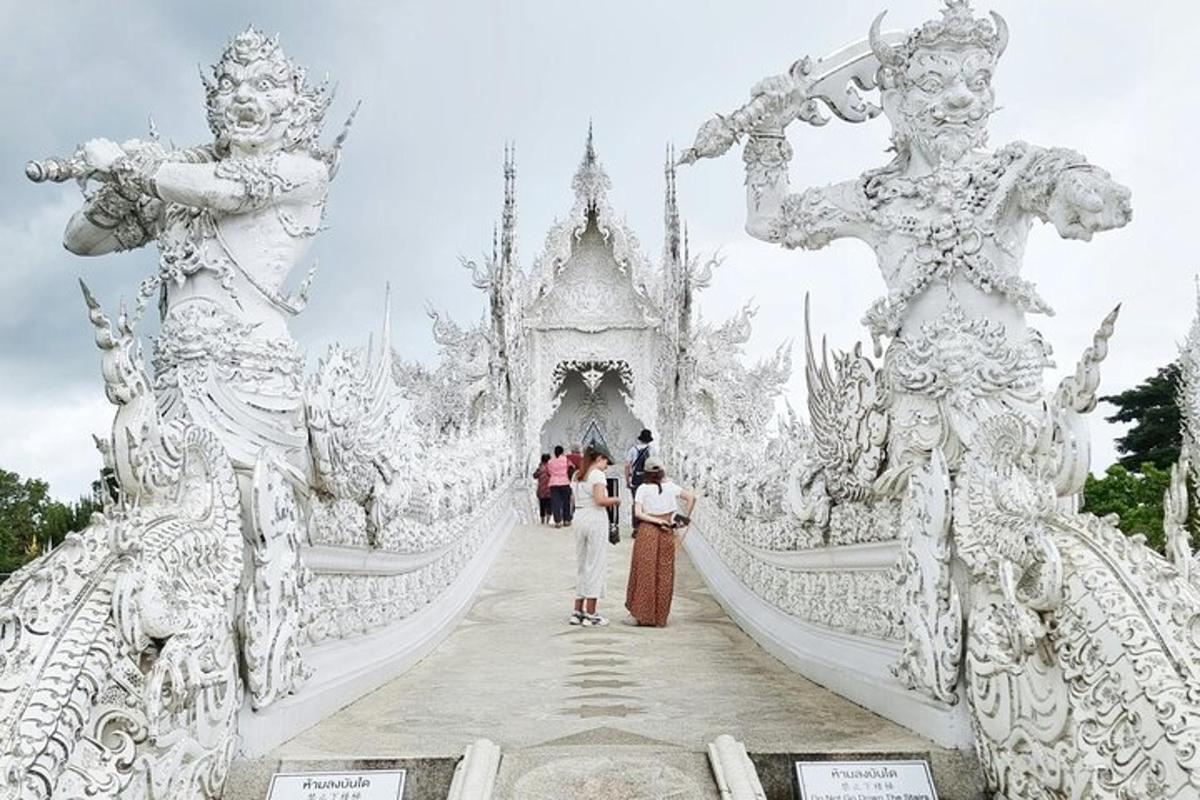 un grup de persones caminant per un pont en un temple blanc