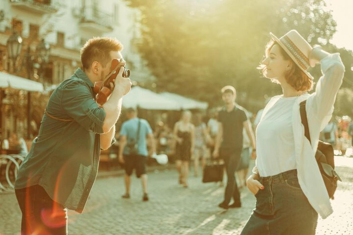 un uomo che scatta una foto a una donna per strada