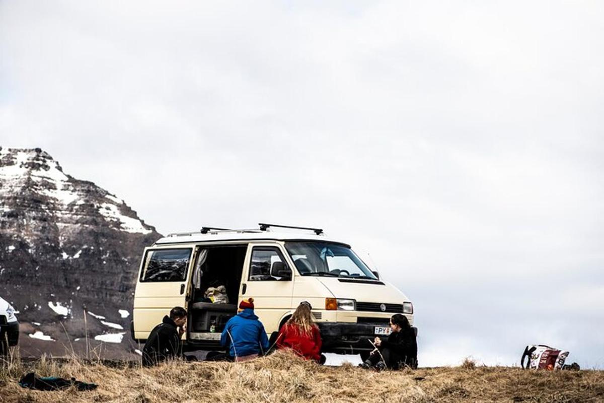 a group of people sitting in front of a van