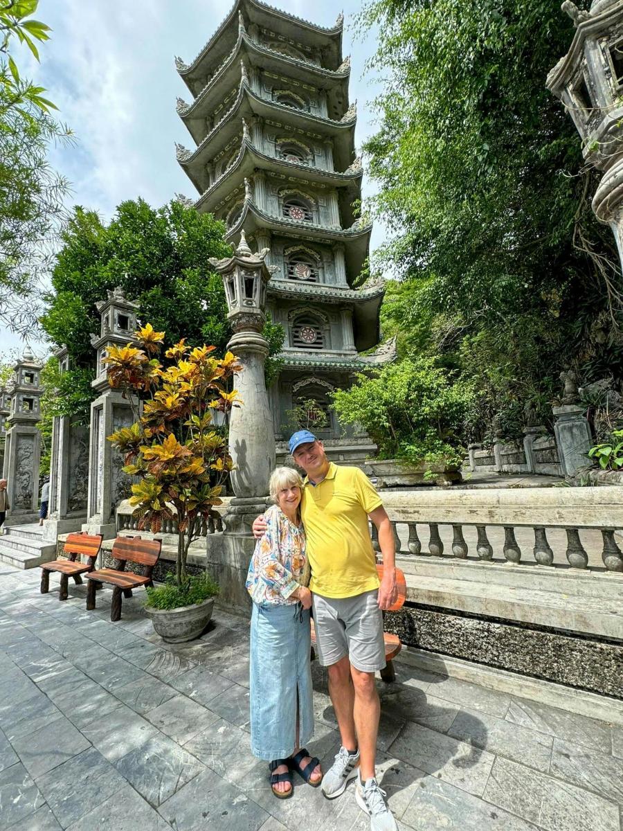 Un hombre y una mujer de pie frente a una pagoda