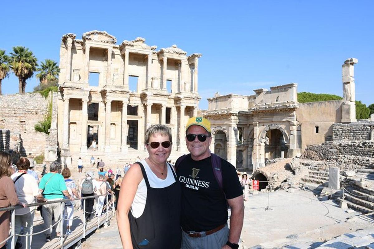 Un hombre y una mujer de pie frente al coliseo.