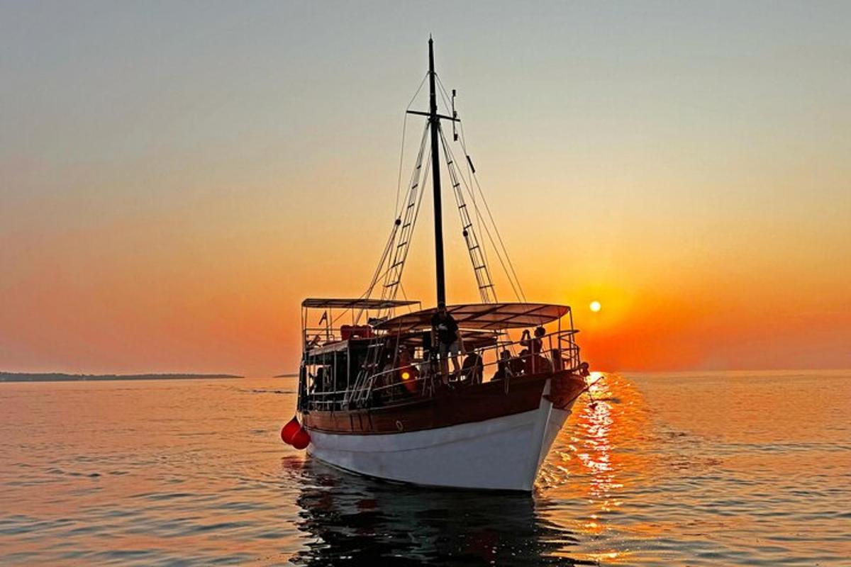 Un barco en el agua con la puesta de sol de fondo