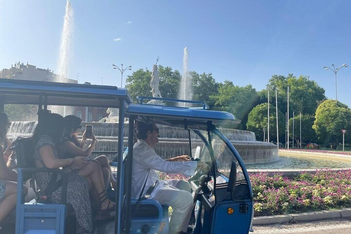 sekumpulan orang menaiki kereta golf di hadapan air pancut