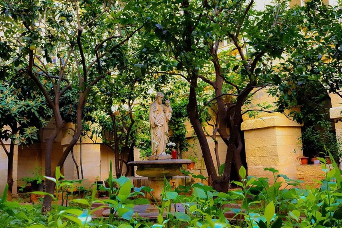 a statue of a woman on a fountain in a garden