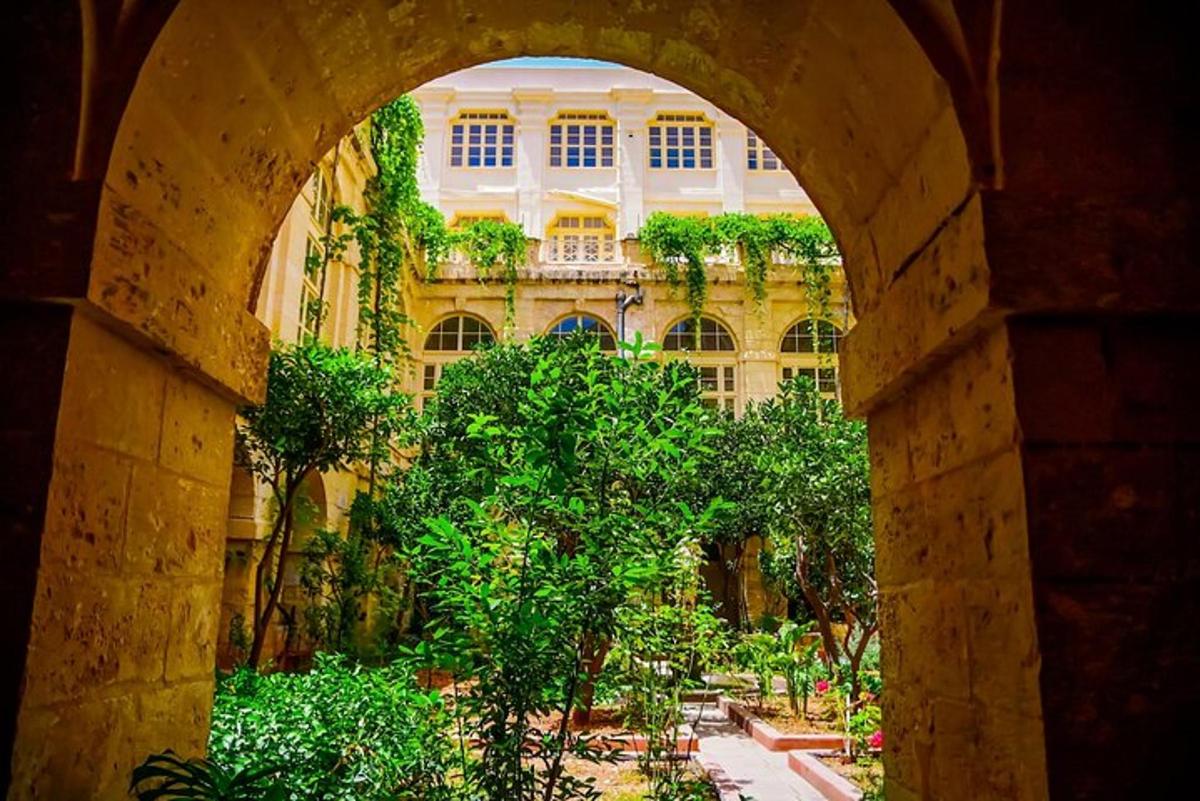 an archway leading to a building with trees in front