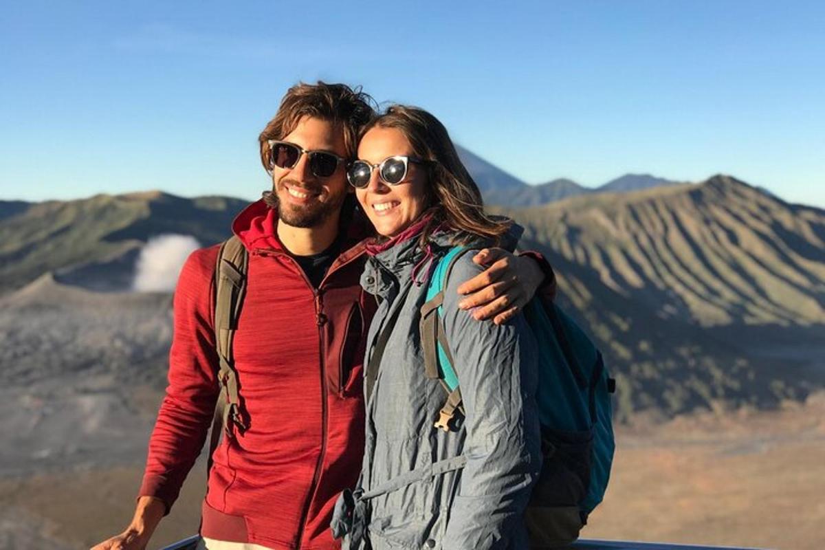 un uomo e una donna in piedi davanti a una montagna