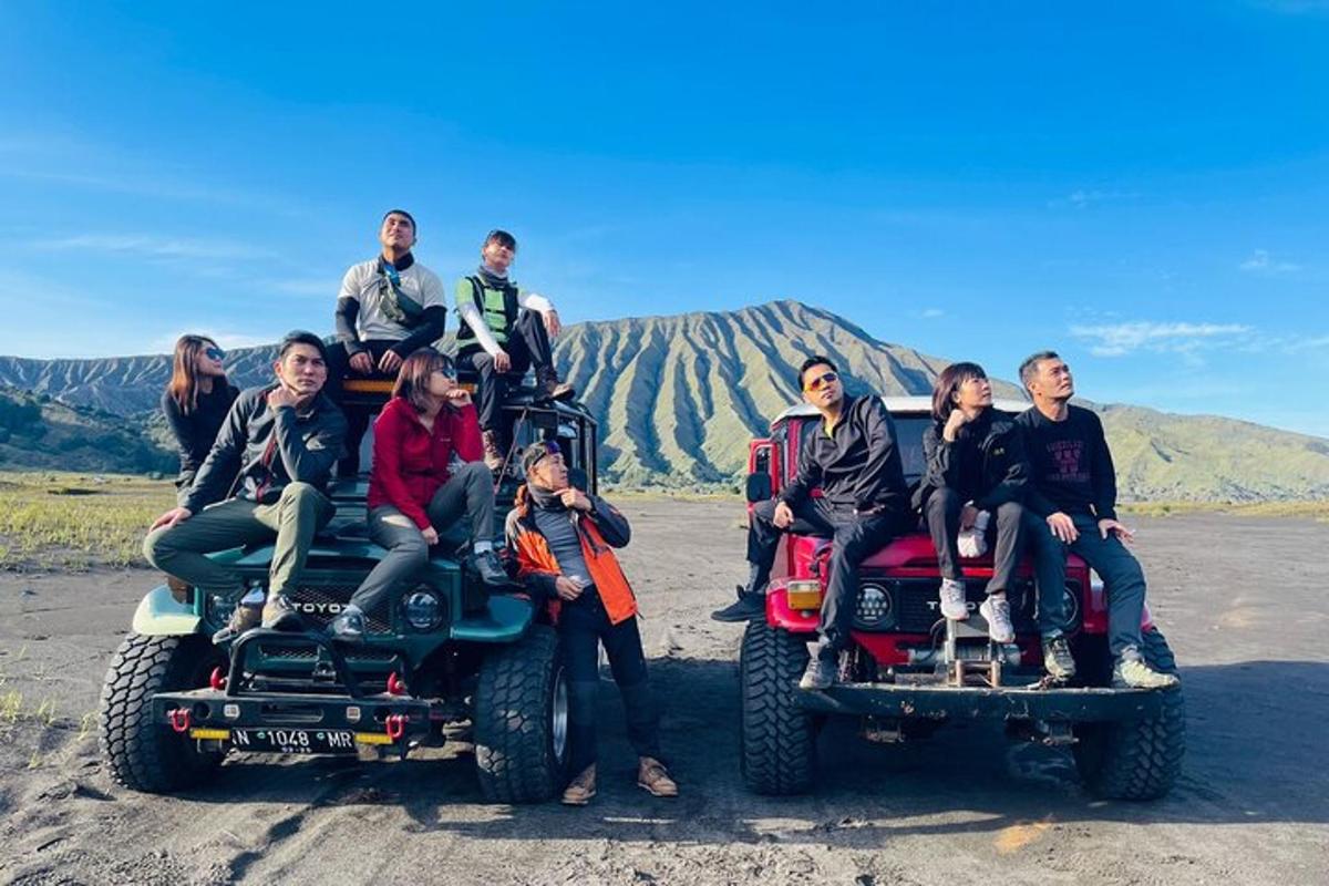 un gruppo di persone sedute sul retro di due jeep