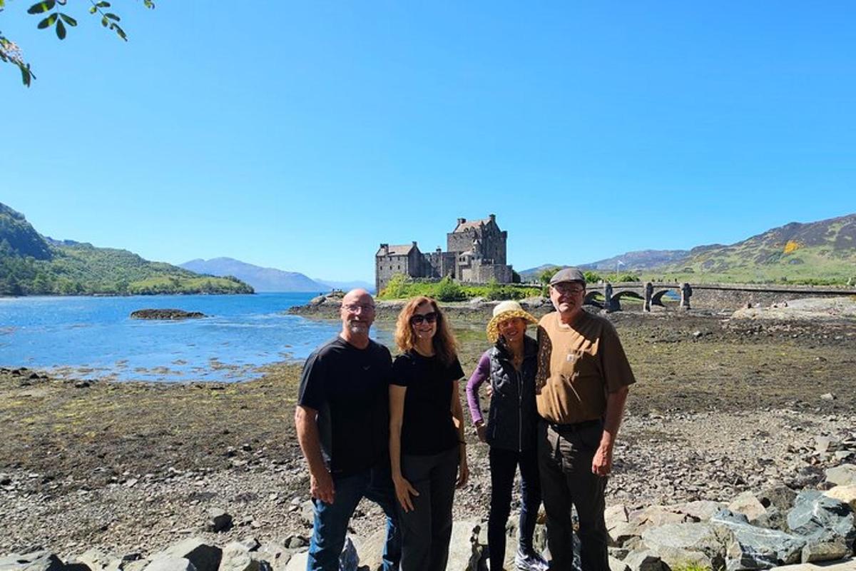 a group of people standing on a beach with a castle in the background