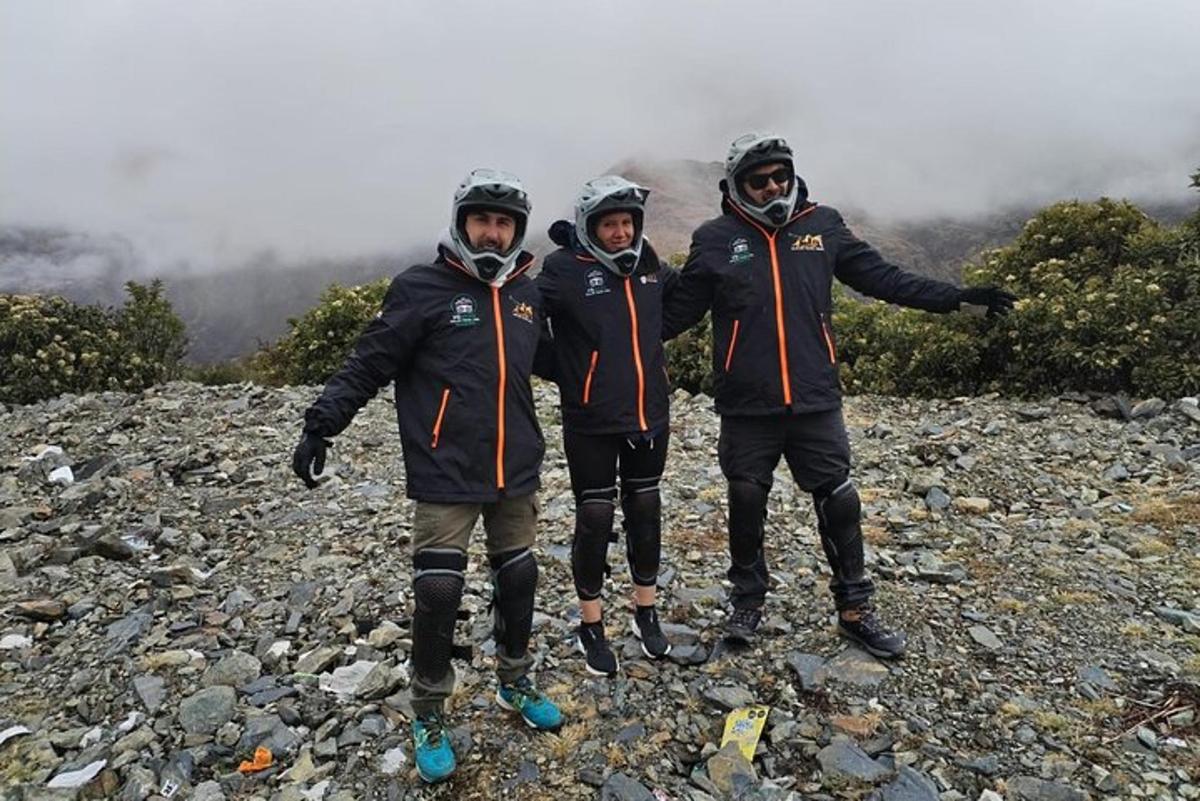 tiga lelaki berdiri di atas gunung berbatu