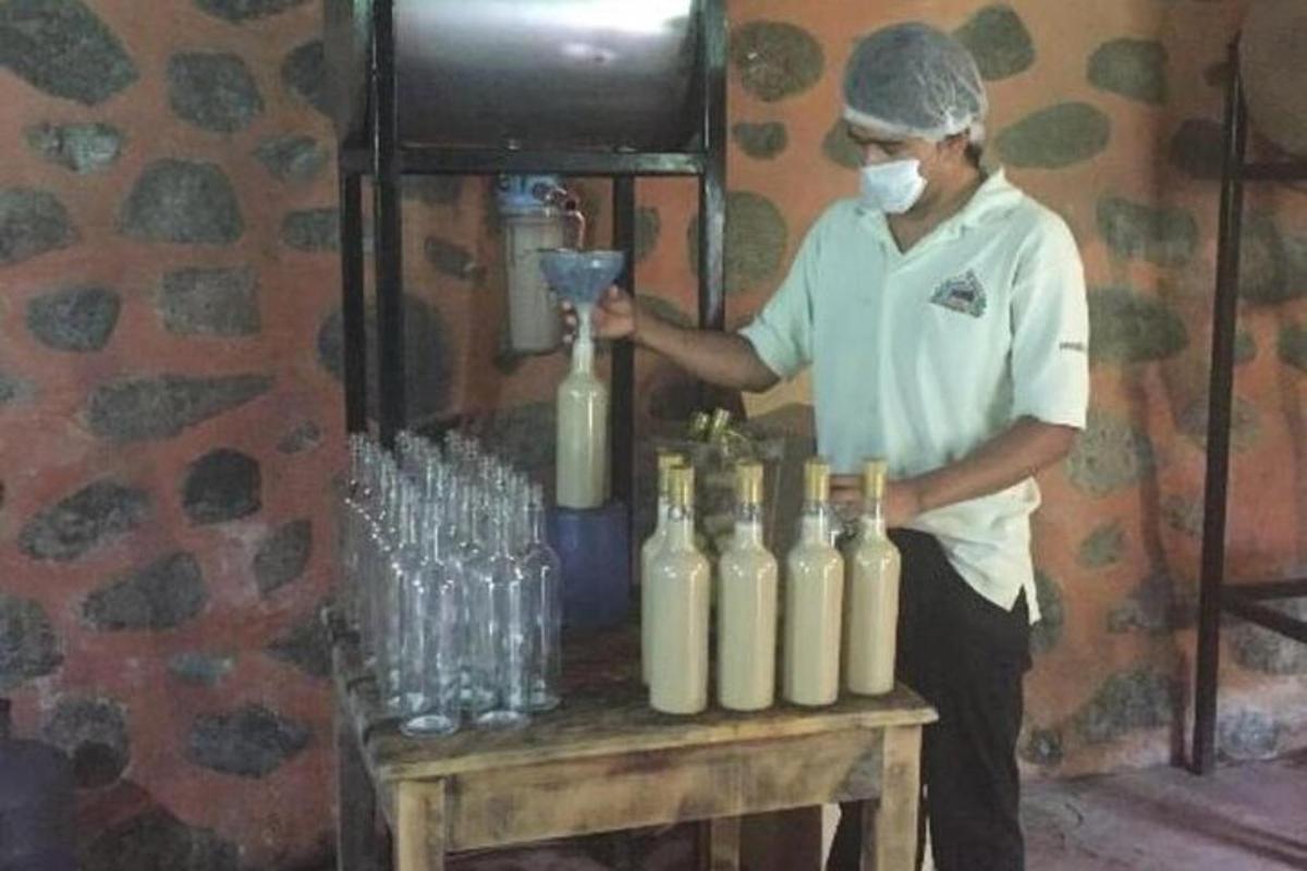 a man standing next to a table with a blender