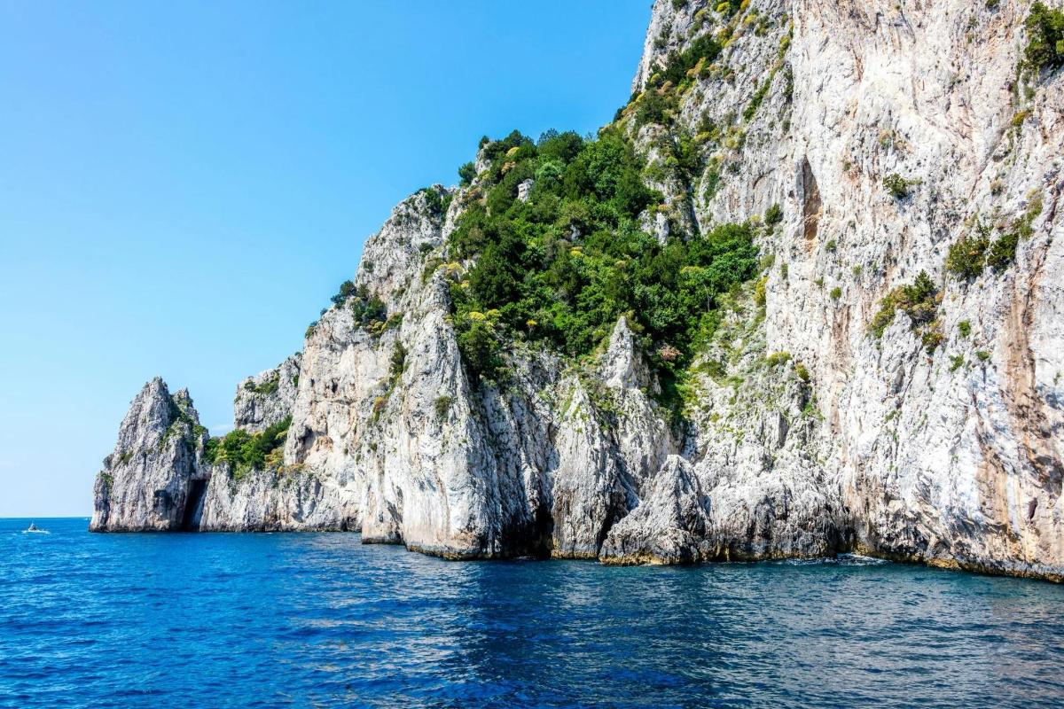uma ilha rochosa no oceano em um dia ensolarado