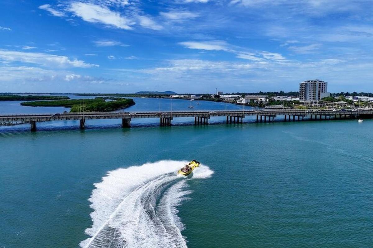 a person water skiing in the water near a bridge
