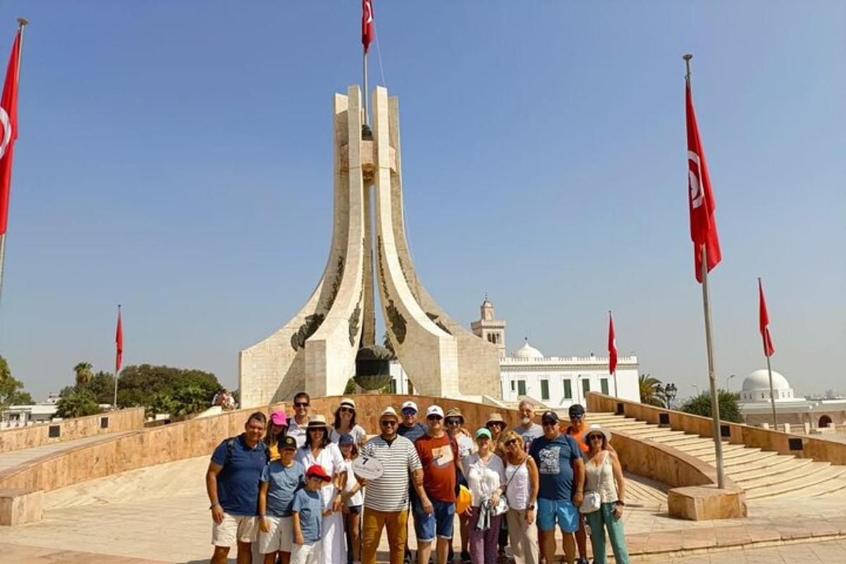 skupina lidí stojící před památníkem
