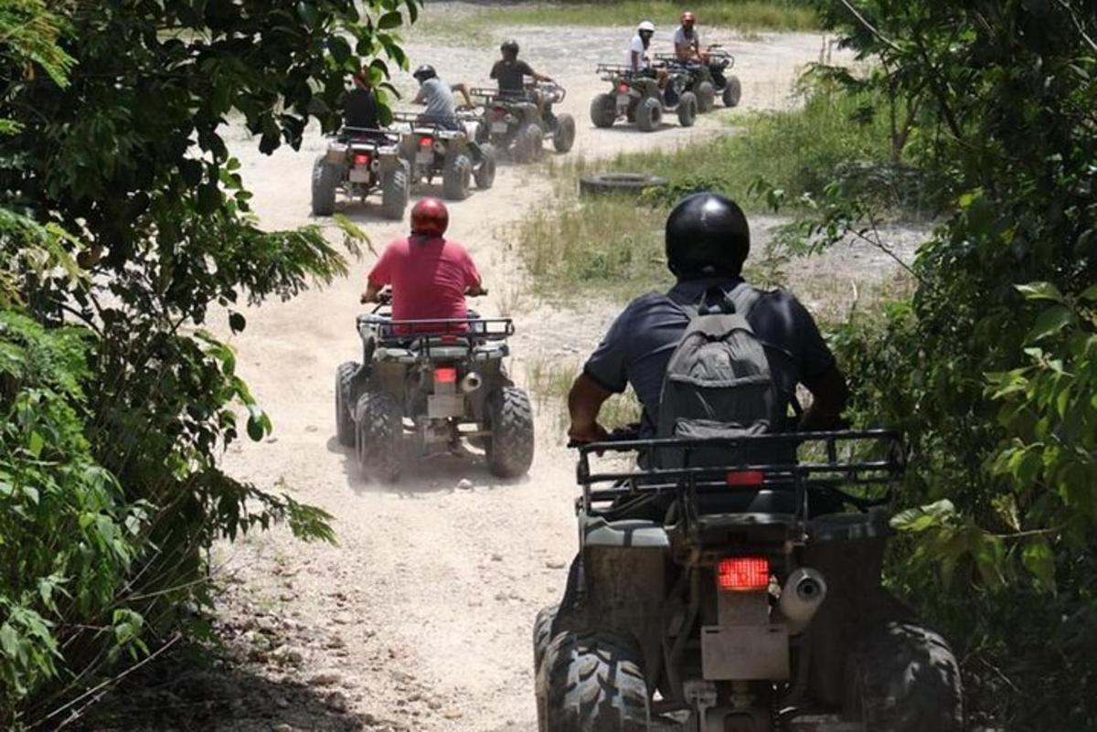 un grup de persones que condueixen motocicletes per un camí de terra