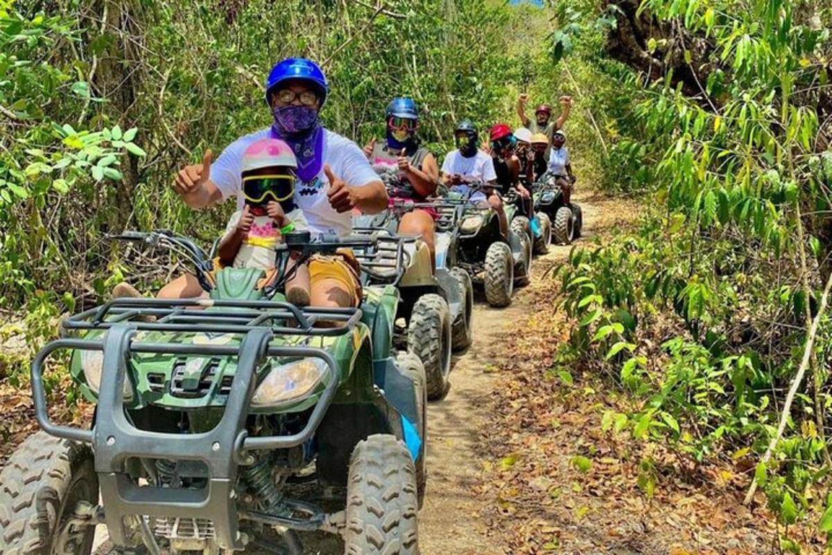 un gruppo di persone che guidano quad su un sentiero