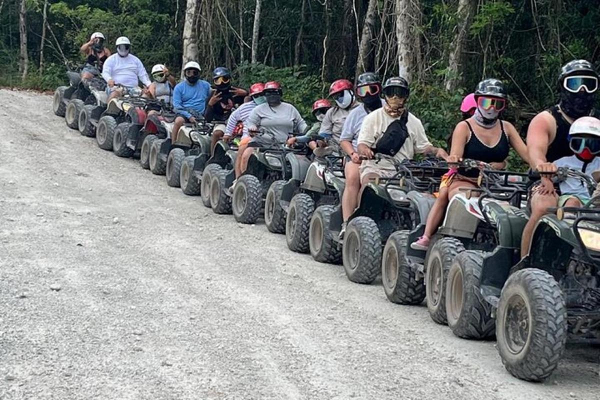un gruppo di persone che guidano quad lungo una strada sterrata
