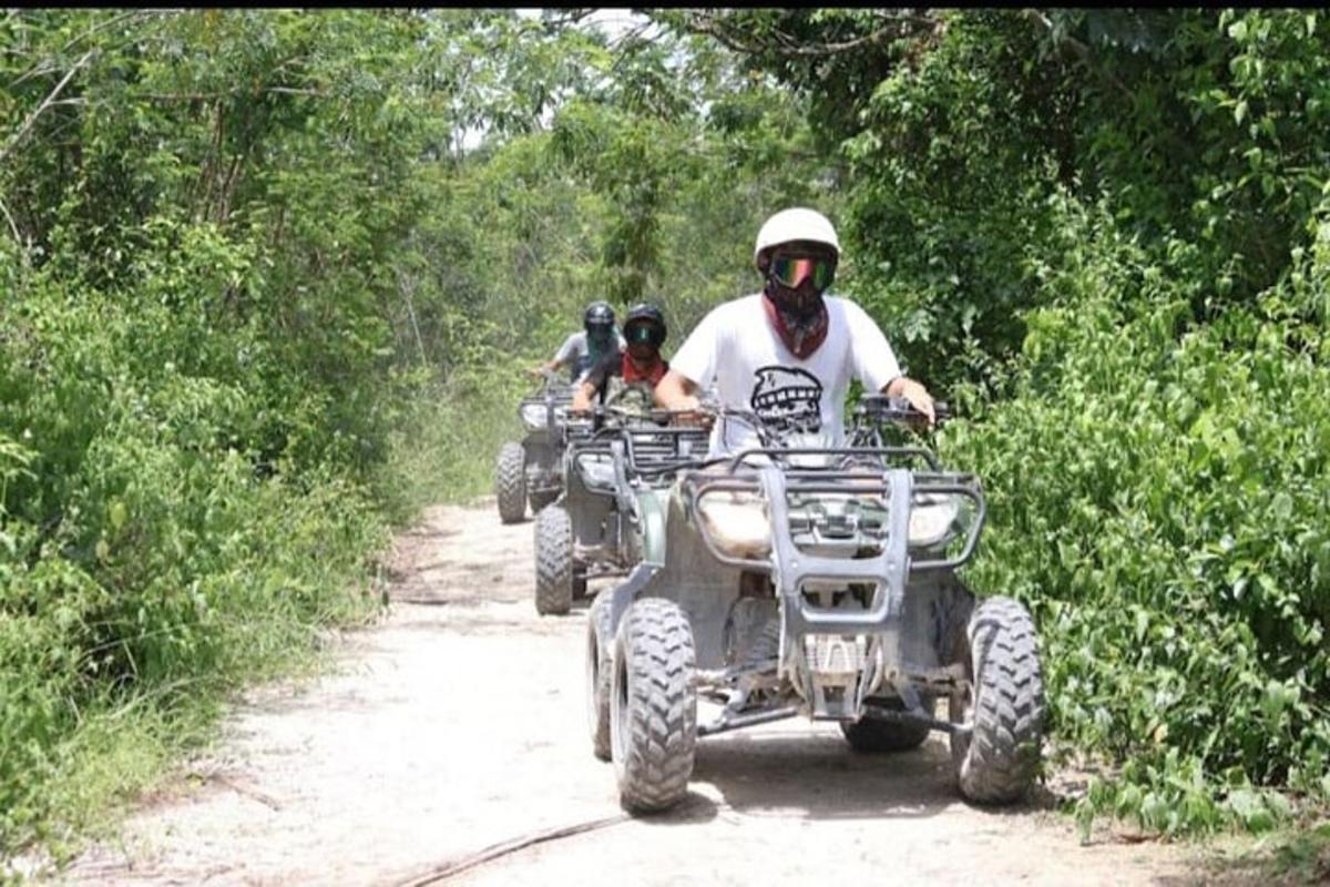 un home en un quad per un camí de terra