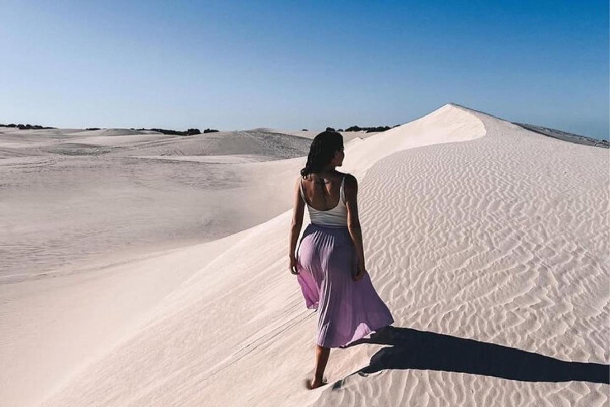 una donna che cammina sulla sabbia nel deserto
