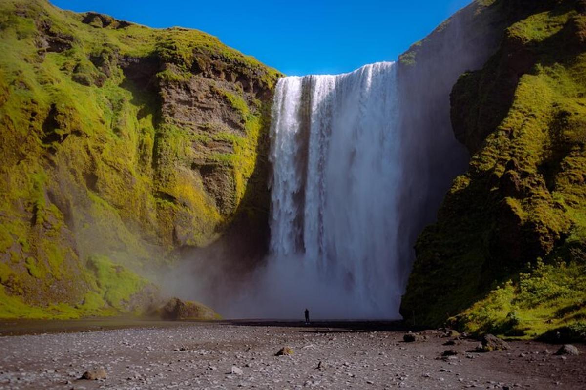 a person is standing in front of a waterfall