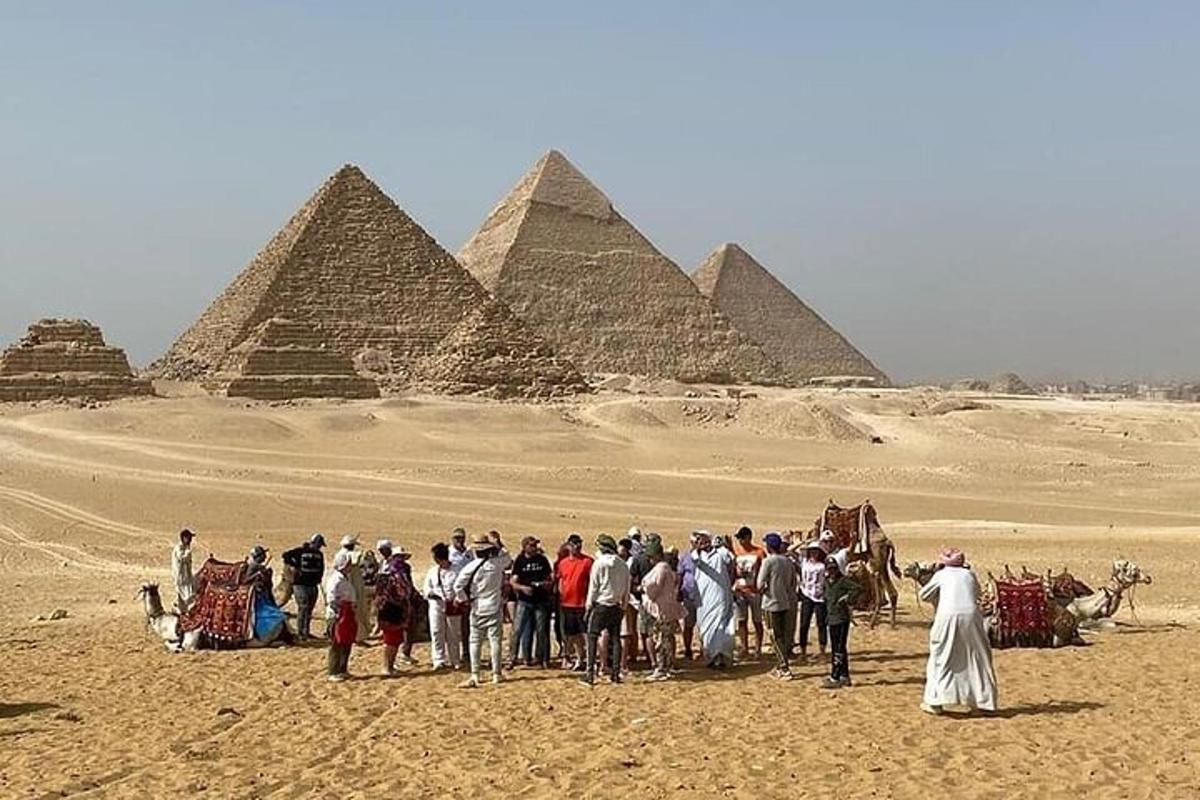 skupina lidí stojící před pyramidami