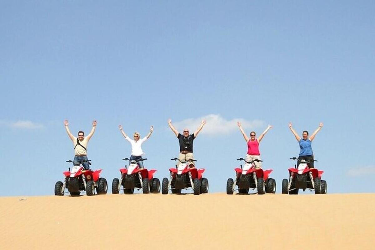 un gruppo di persone su quad nella sabbia