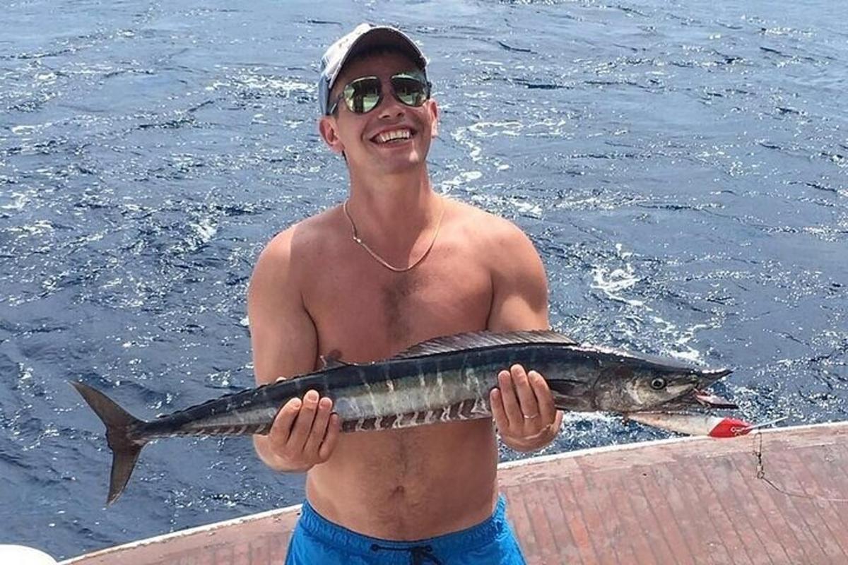 ein Mann, der einen großen Fisch in seinen Händen hält
