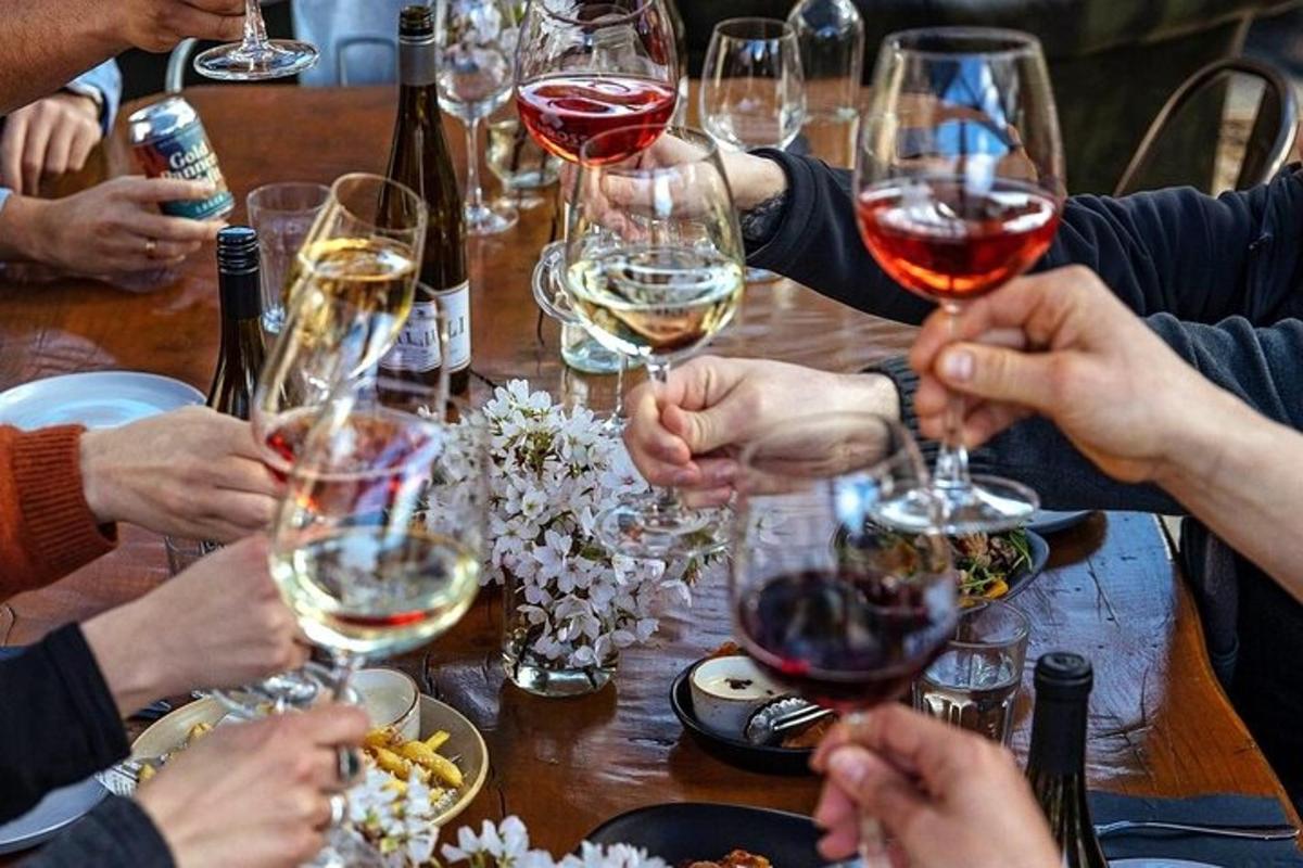 skupina lidí sedících kolem stolu s vinnými sklenicemi
