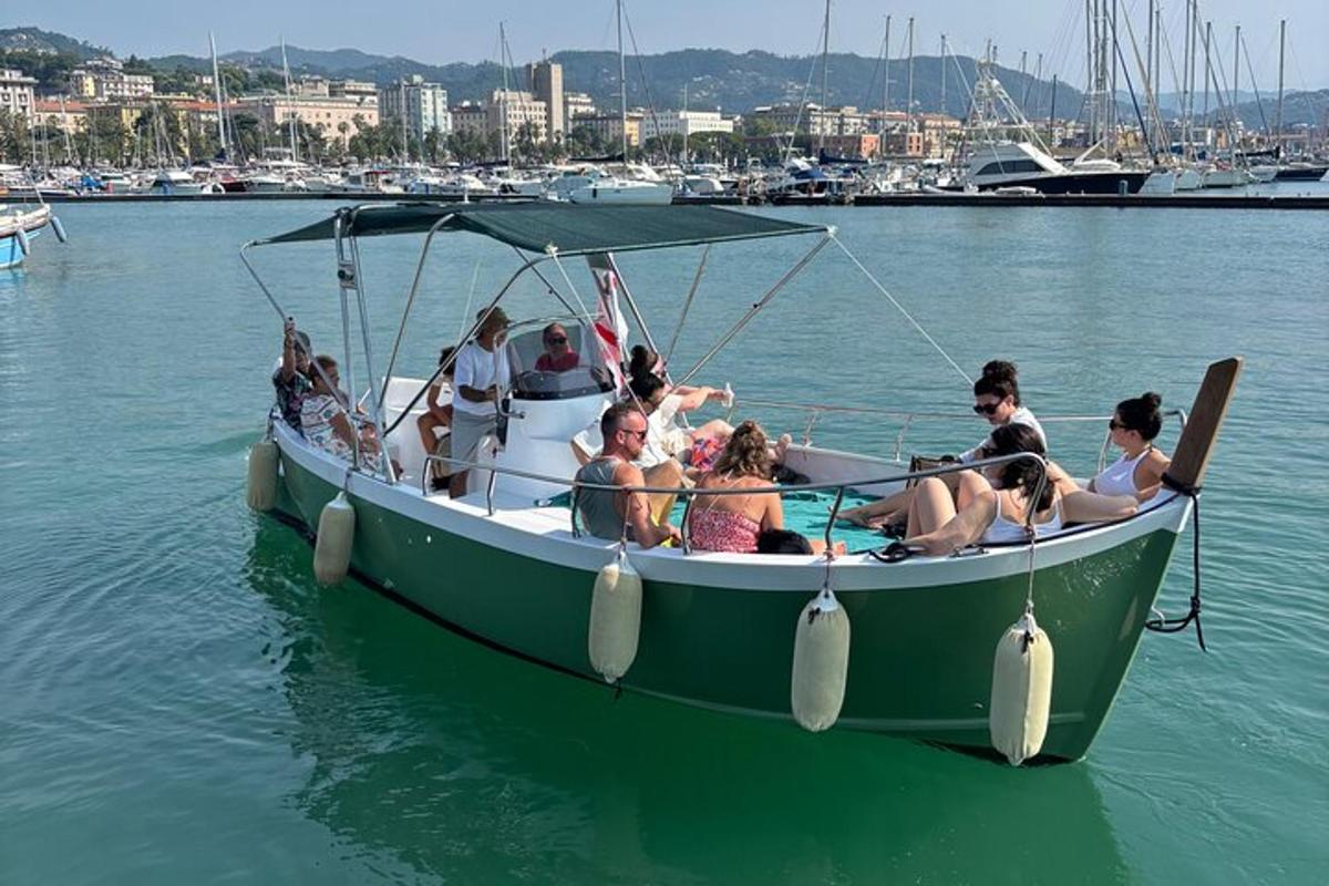 a group of people sitting in a green boat in the water