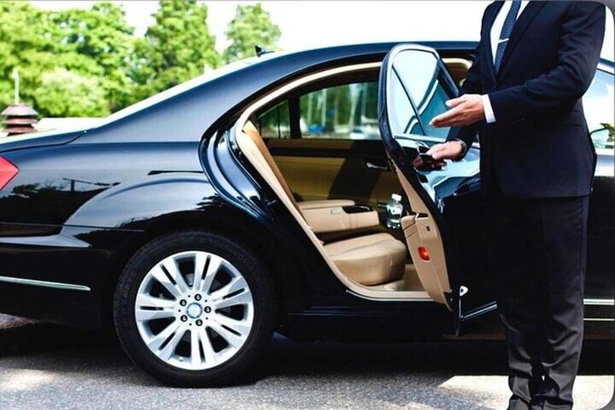 muškarac u odijelu otvara vrata automobila