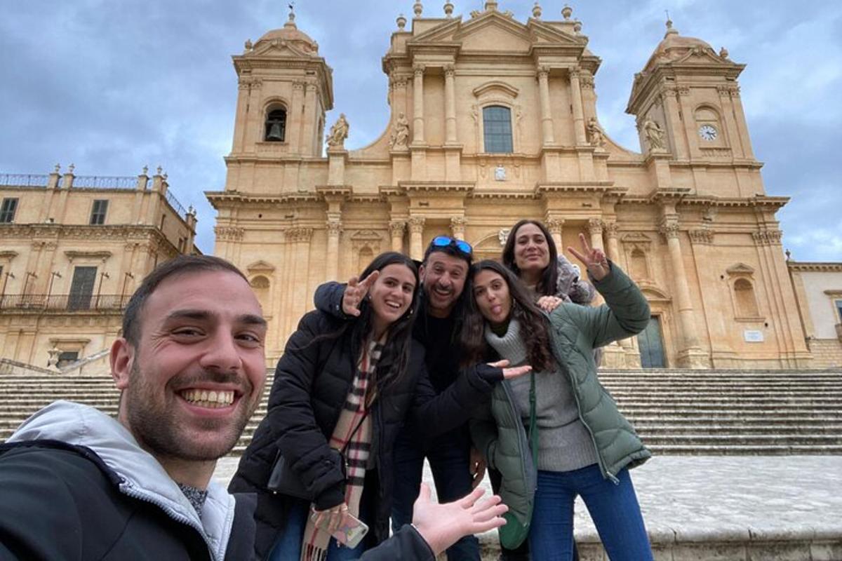 Un grupo de personas posando frente a un edificio.
