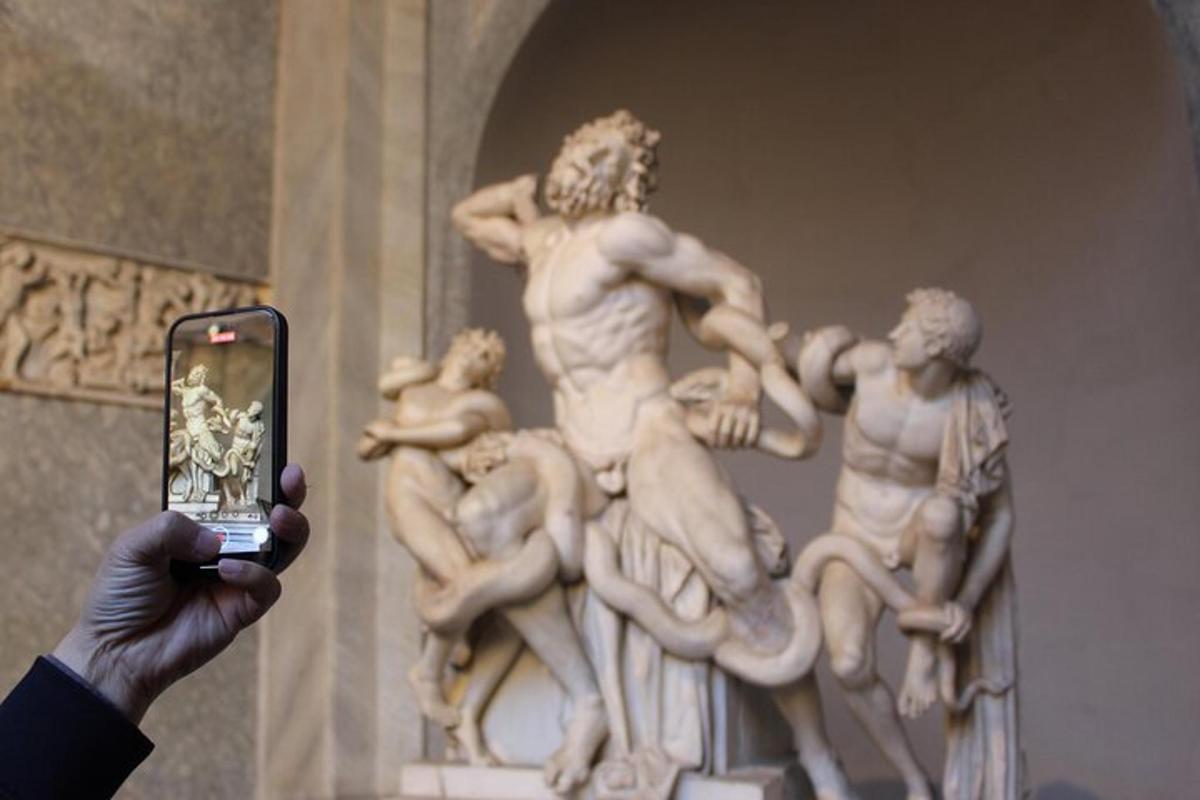 a person taking a picture of a statue with a cell phone