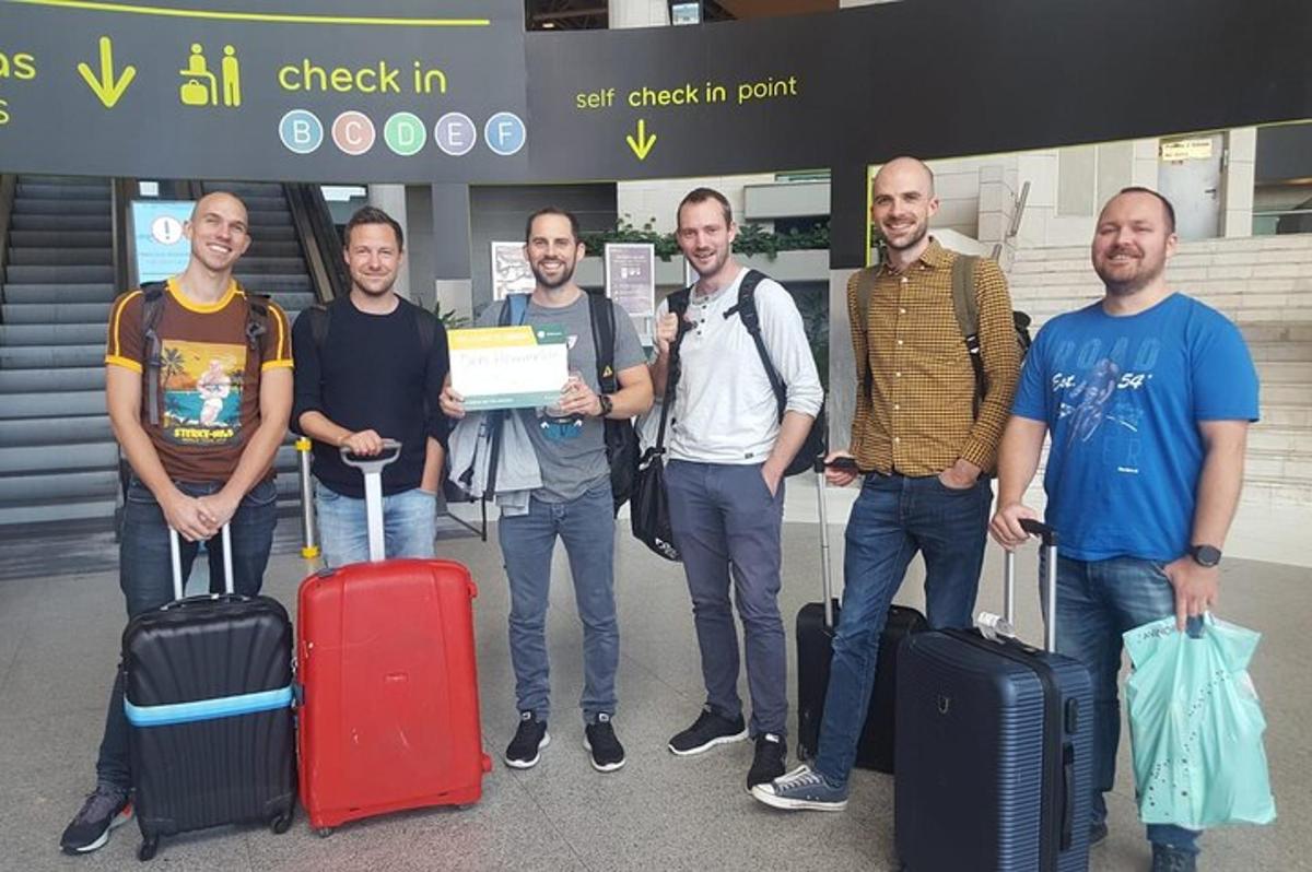 un gruppo di uomini in piedi con i bagagli in un aeroporto